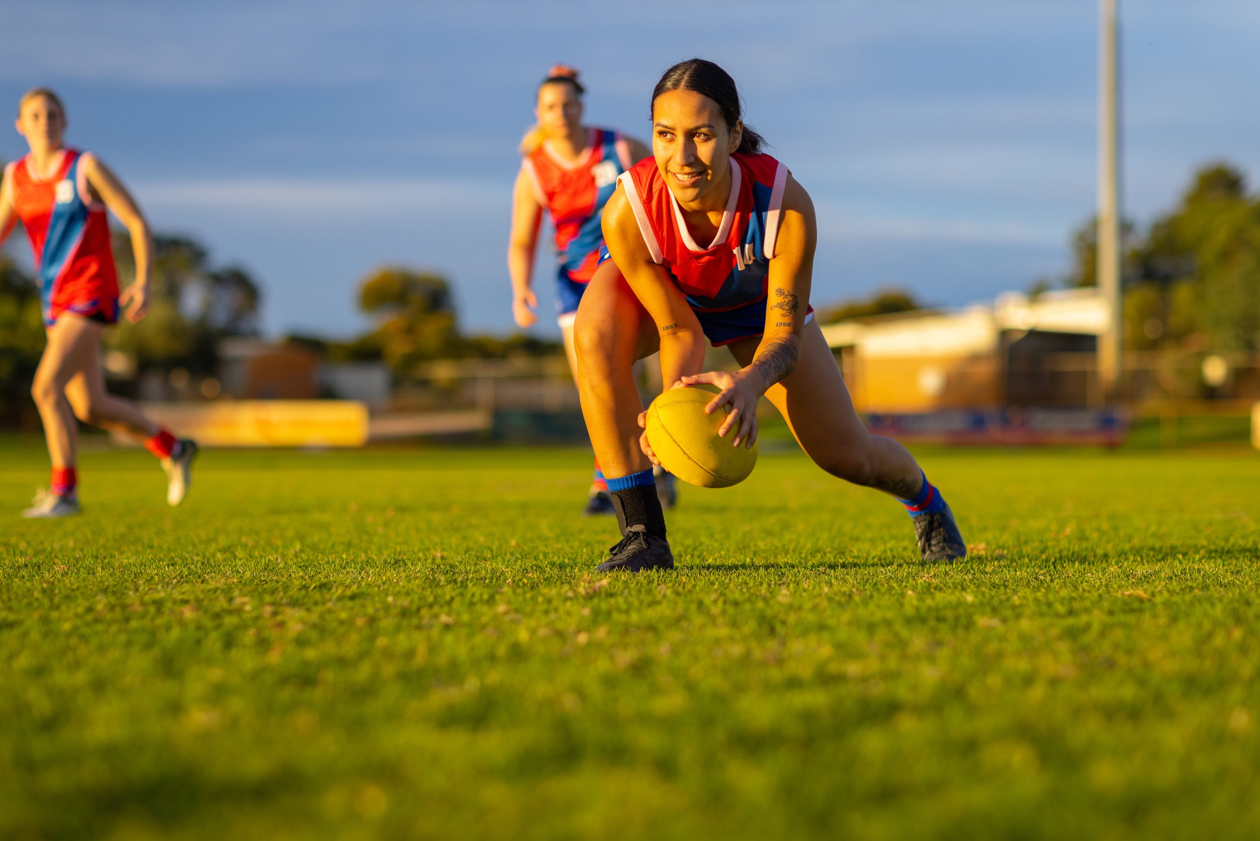 Female AFL Player Running with the ball